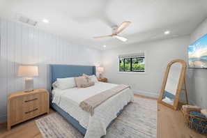 A bedroom with a bed, bedside tables, a ceiling fan, a window, and a wall-mounted TV. - Brand New - Gorgeous 3 Bedroom 3 Bathroom (Naples)