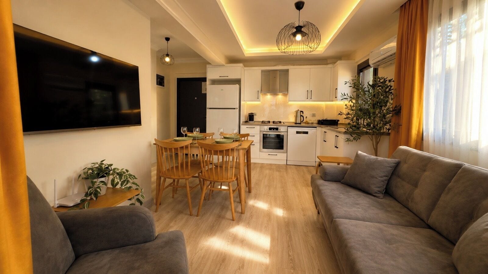 A modern living room with a sofa, a dining table with chairs, a kitchen area with cabinets and appliances, and a large window with curtains.