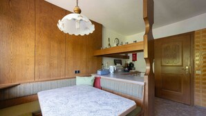 Una cucina con mobili in legno, un piano di lavoro in marmo e un lampadario.