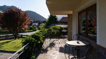 Ein Balkon mit Steinboden, einem Tisch und Stühlen.