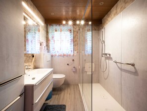 Un baño moderno con ducha, inodoro y tocador.