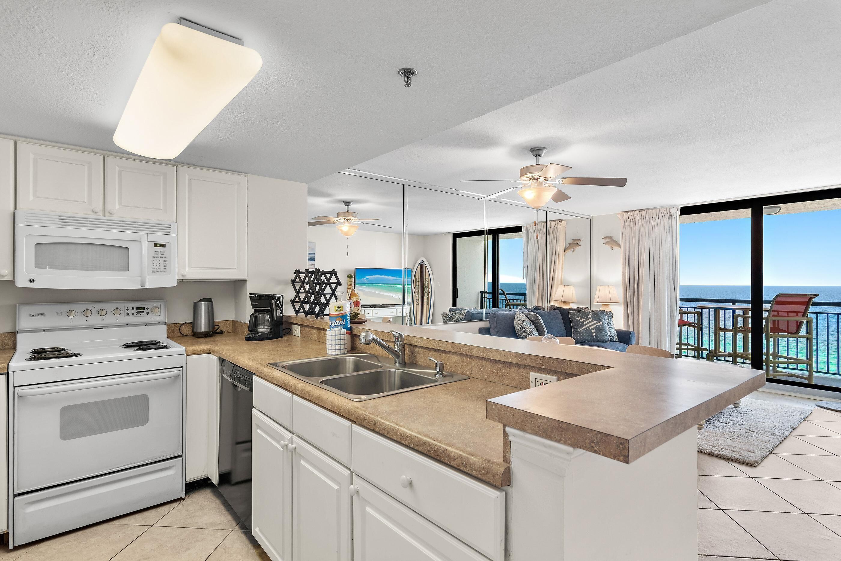 A modern kitchen with a central island, a built-in oven, and a microwave.
