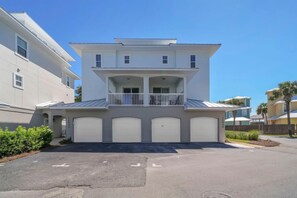 A two-story residential building with a balcony, a garage, and a driveway. - Sunny Beach Days (Panama City Beach)