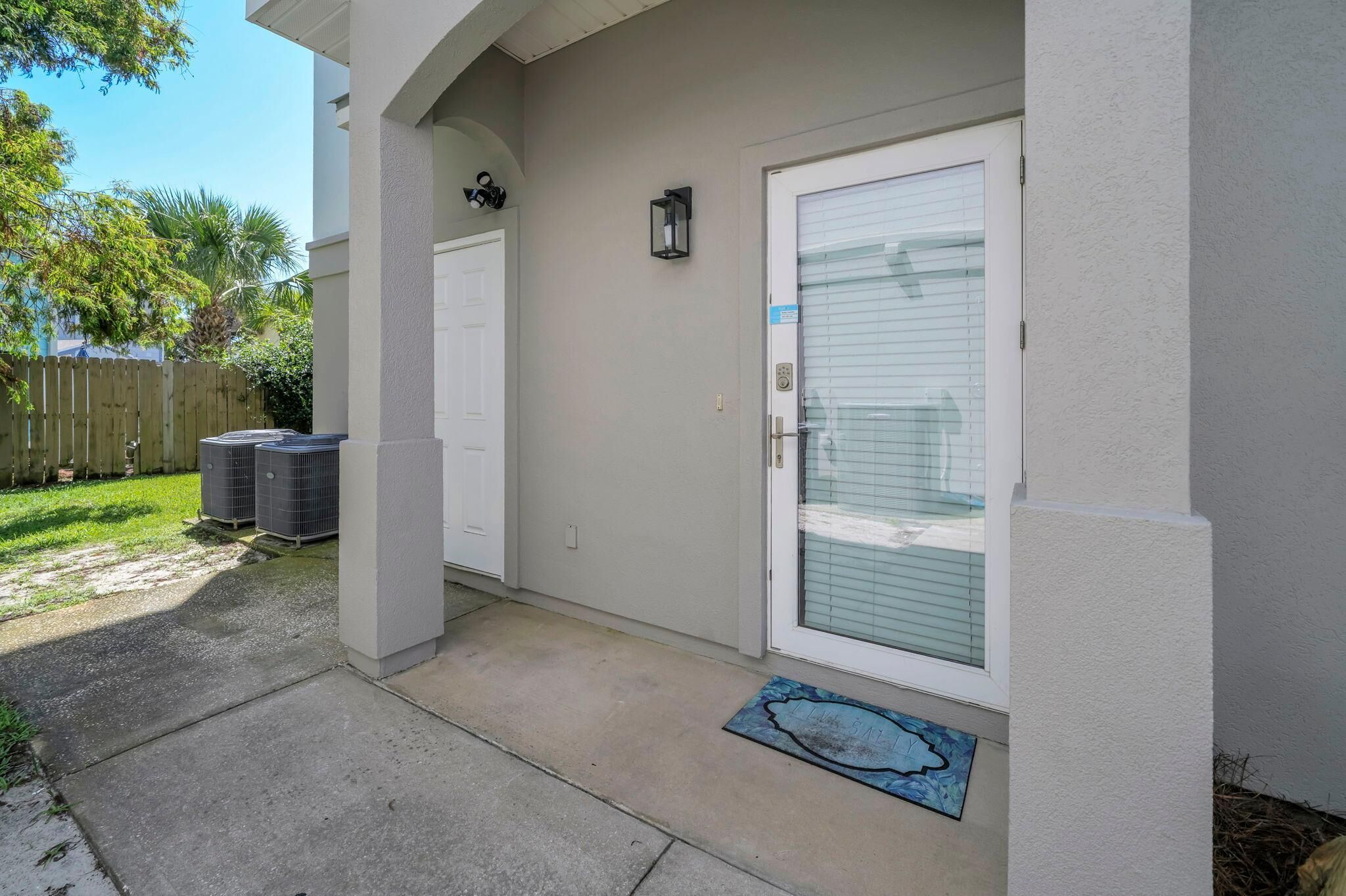 A residential entrance with a white door, a mailbox, and a small porch area.