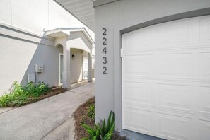 A residential building with a garage door, a driveway, and a number '22432' on the wall. - Sunny Beach Days (Panama City Beach)