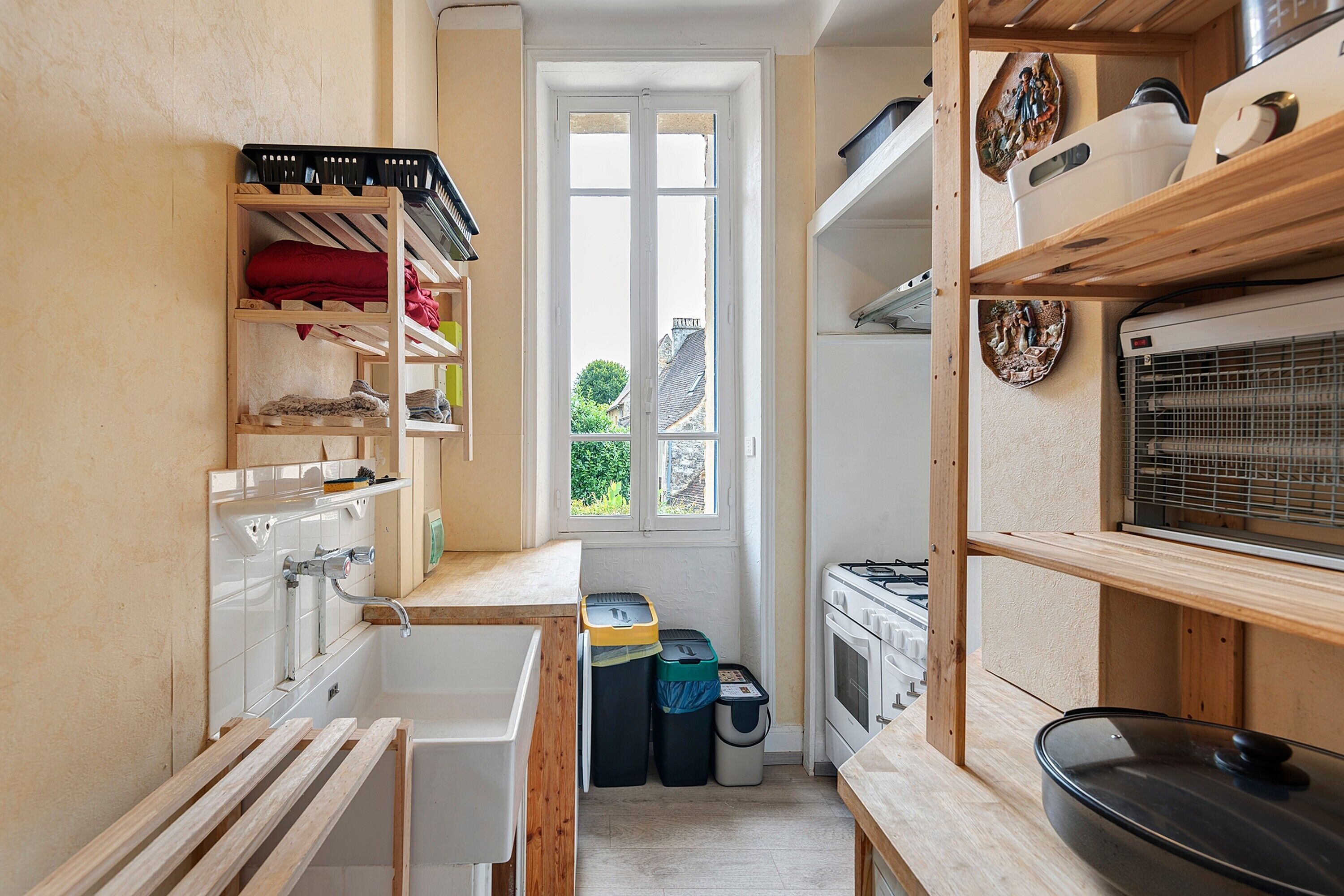 A compact kitchen with a window, a stove, and a sink.