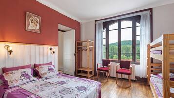 Une chambre à coucher avec un lit, une chaise, une armoire en bois et une fenêtre donnant sur un beau paysage.