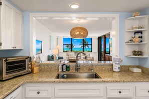 A modern kitchen with a built-in toaster, a sink, and a countertop with a dish soap dispenser. - Wake up to breathtaking direct Gulf-front views at Loggerhead Cay 142. This beautifully updated 2-bedroom, 2-bath beachfront condo sleeps 5 and includes beach gear, a heated pool, pickleball, and everything you need for the perfect Sanibel getaway. (Sanibel Island)