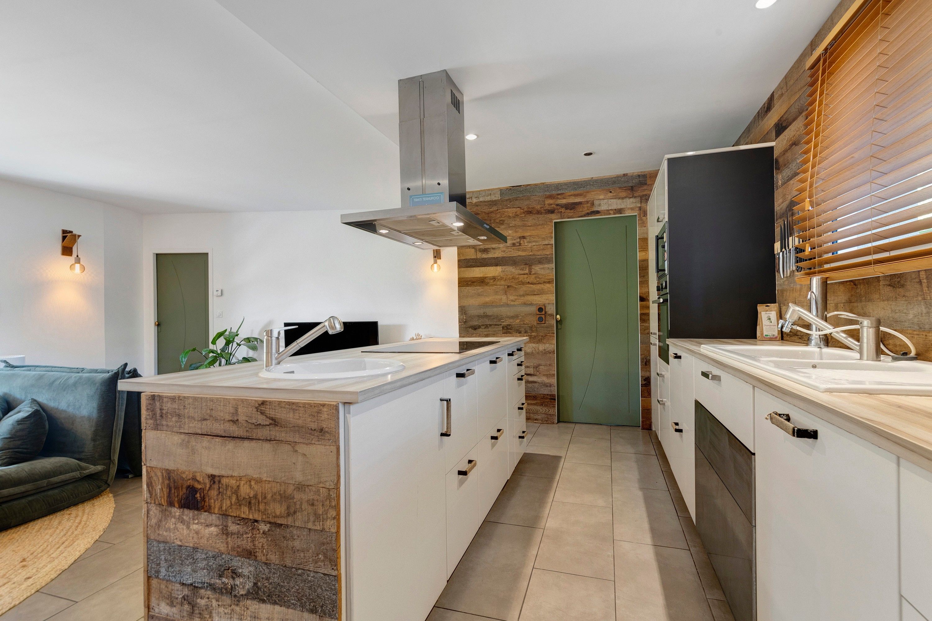 Une cuisine moderne dotée d’un îlot central, de touches de bois et d’un four encastré.