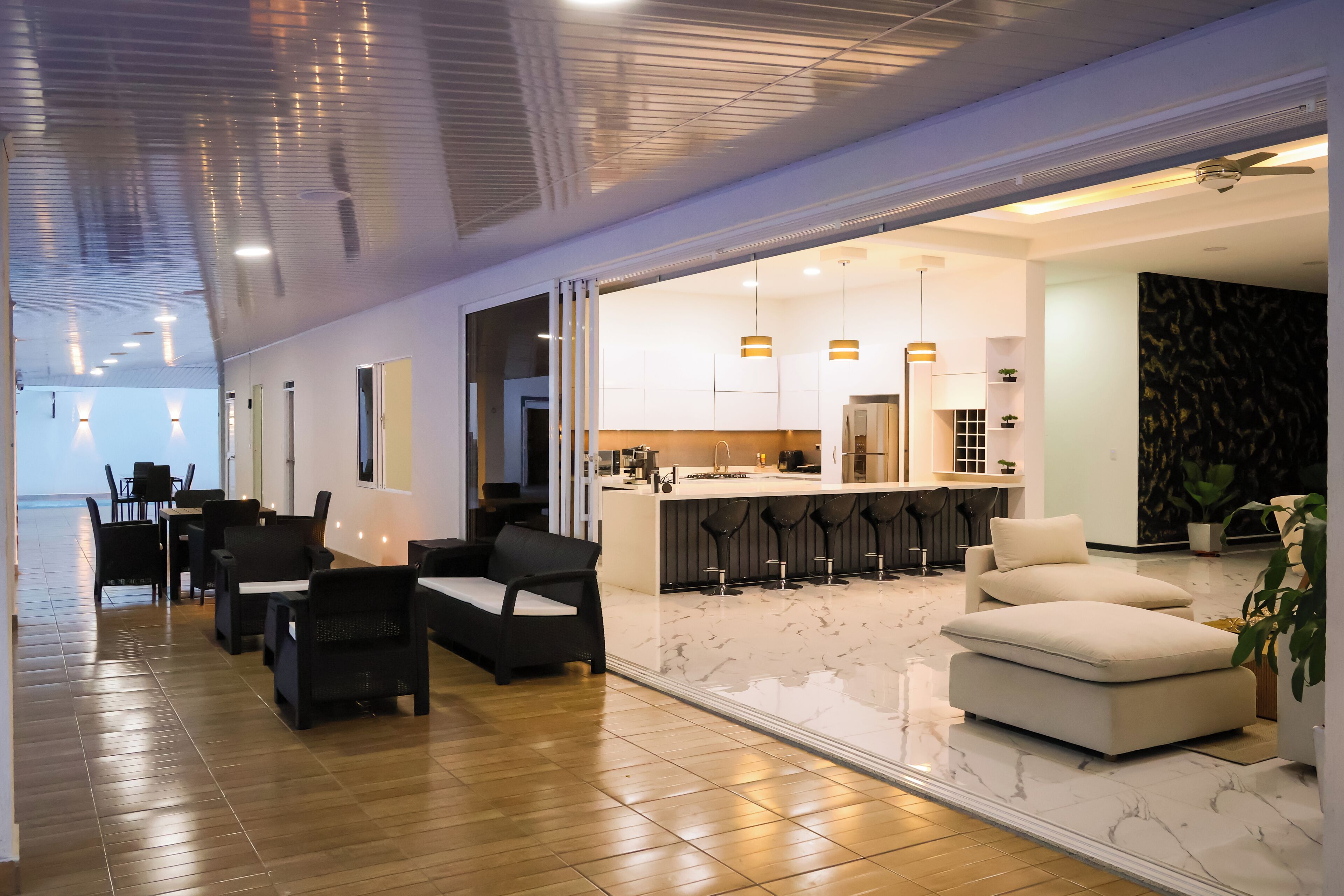 Un intérieur moderne comprenant un coin repas, une cuisine et un espace salon.