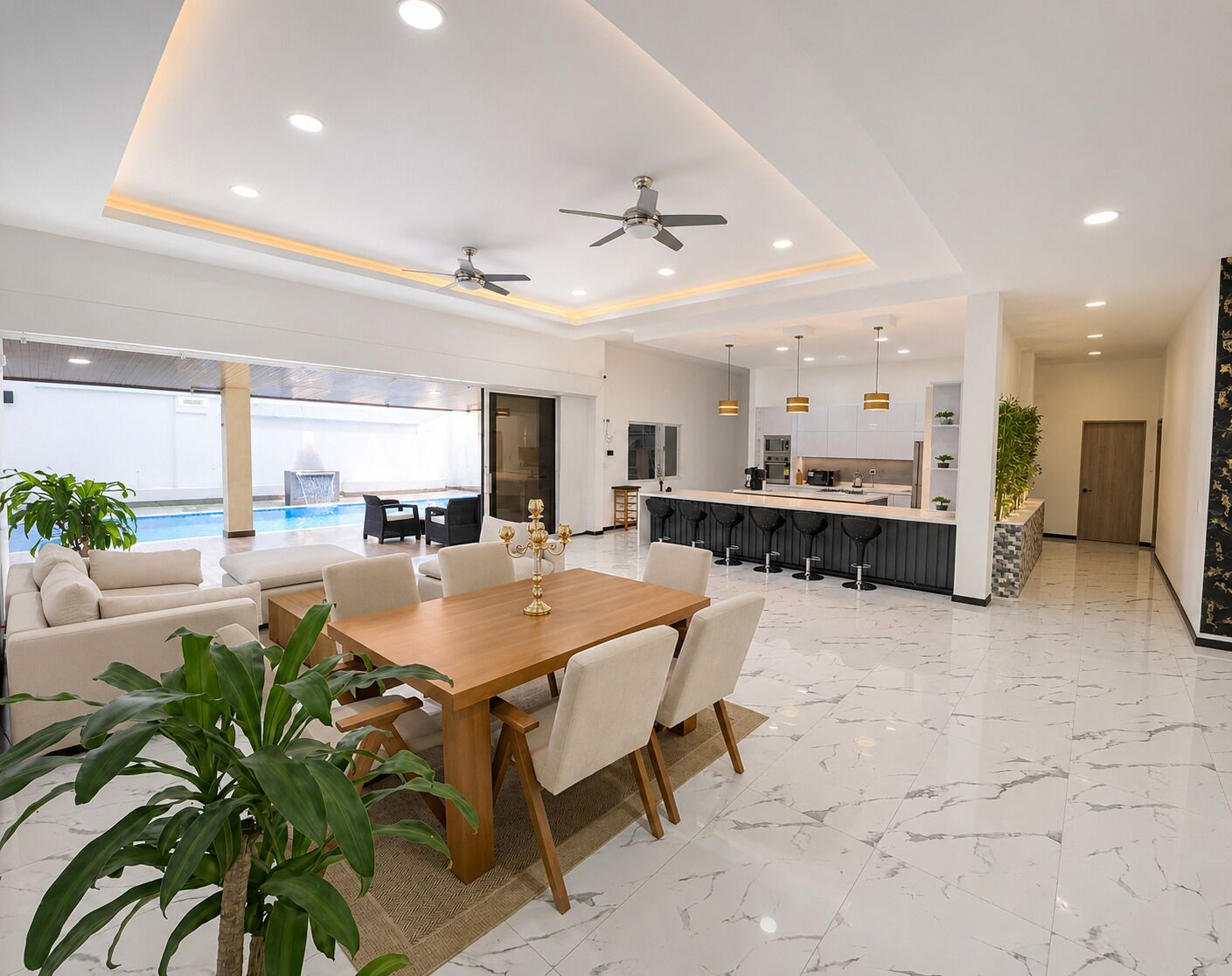 Un salon moderne comprenant un coin repas, une cuisine et un espace piscine.