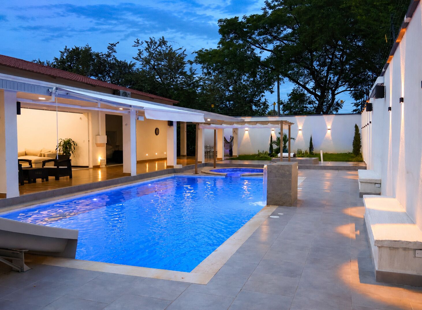 Une piscine dotée d’un espace détente couvert et d’une terrasse.