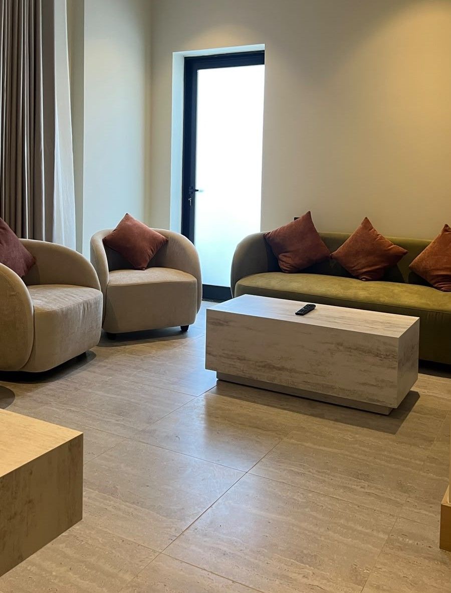 A modern living room with two sofas, a coffee table, and a door leading outside.