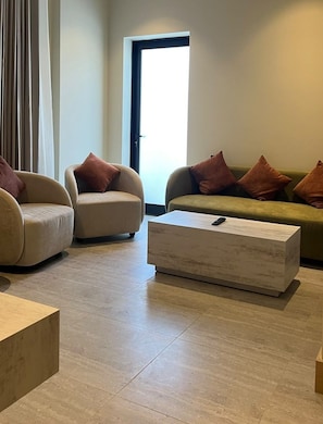 A modern living room with two sofas, a coffee table, and a door leading outside. - Best western centria (Riyadh)