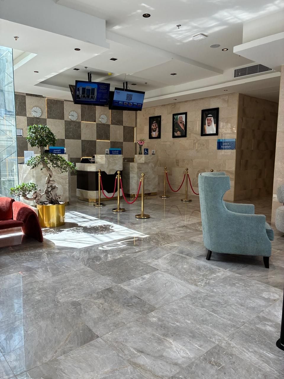 Una hall d'albergo con reception, area salotto e banco accettazione.