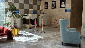 Una hall d'albergo con reception, area salotto e banco accettazione.