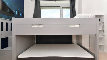 A bunk bed with a pull-out desk and a night sky mural on the wall.