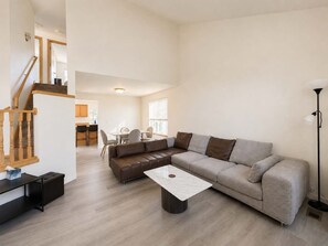 A spacious living area with a sofa, a coffee table, and a dining table with chairs. - Quiet Renton 3BR House near Valley Medical Ctr (Renton)