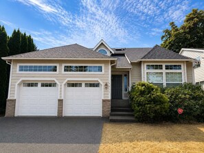 A two-story house with a garage, a front door, and a small porch. - Quiet Renton 3BR House near Valley Medical Ctr (Renton)