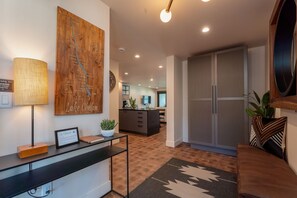 Ein modernes Interieur mit einer Rezeption, einer großen Wandkarte, einer Küchenzeile und einer Sitzecke mit einem gemusterten Teppich.