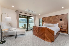 Un dormitorio con cama, escritorio, silla y vistas al exterior.