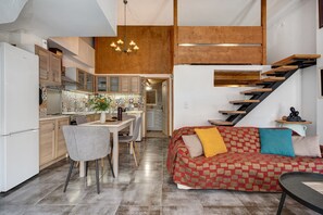A modern kitchen with a dining area, a staircase, and a living room with a patterned sofa. - Country House 'Rahati Suite' with Private Terrace and Wi-Fi (Tzermiado)