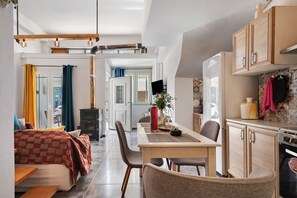 A modern kitchen with wooden cabinets, a built-in oven, and a dining area with a table and chairs. - Country House 'Rahati Suite' with Private Terrace and Wi-Fi (Tzermiado)