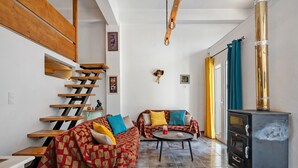 Un salon moderne avec un escalier, un ensemble de canapés, une table basse et une cheminée.