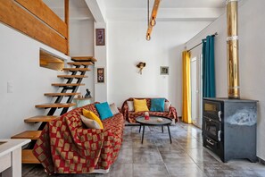 Ein modernes Wohnzimmer mit Treppe, einer Sofagarnitur, einem Couchtisch und einem Kamin.