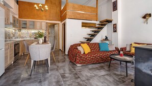 Un intérieur moderne comprenant une cuisine, un coin repas et un espace de vie, le tout agrémenté d’un escalier.