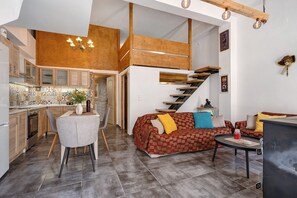 Ein modernes Interieur mit Küche, Essbereich und Wohnbereich, ergänzt durch eine Treppe.