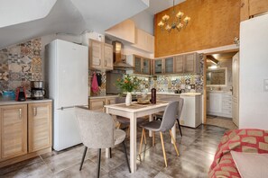 Eine moderne Küche mit Essbereich, Holzschränken, einem weißen Kühlschrank und einer Kandelaber.