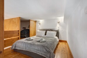 Ein gemütliches Schlafzimmer mit einem Bett, einem Holzschrank und einer kleinen Sitzecke.