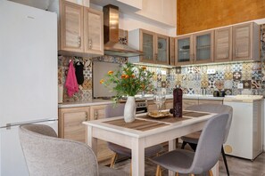 A modern kitchen with wooden cabinets, a central island, and a dining table with chairs. - Country House 'Rahati Suite' with Private Terrace and Wi-Fi (Tzermiado)