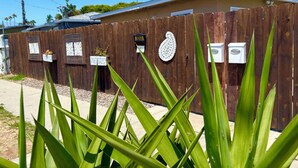 Un bâtiment en bois avec une boîte aux lettres, une boîte aux lettres portant un numéro et une boîte aux lettres dotée d’un couvercle décoratif.