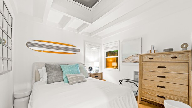 A bedroom with a bed, a wooden dresser, a wall-mounted shelf, and a window with blinds. - Perfect 4 Families, Walk To Beach, Roof-Top Patio! (Oxnard)