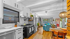 A modern kitchen with a large stove, oven, and white cabinets. - Perfect 4 Families, Walk To Beach, Roof-Top Patio! (Oxnard)