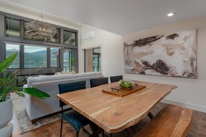 A dining area with a wooden table, chairs, and a view of the outdoors. - Lakefront Condo B3  Pool in Wapato Point Chelan (Manson)
