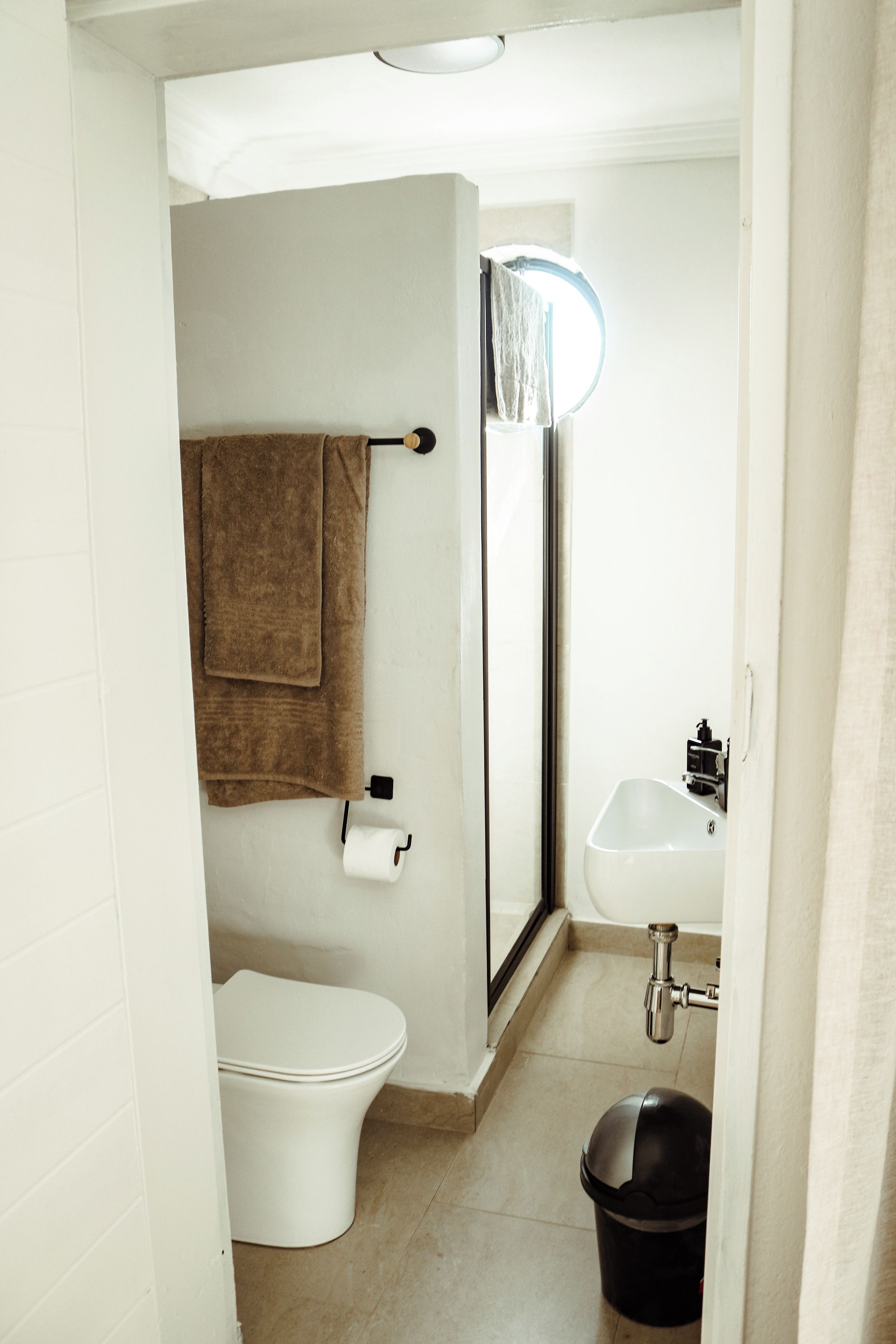 Een kleine badkamer met toilet, wastafel en douche.