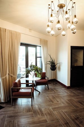Una habitación con una mesa de comedor, sillas, una planta en maceta y una lámpara colgante.