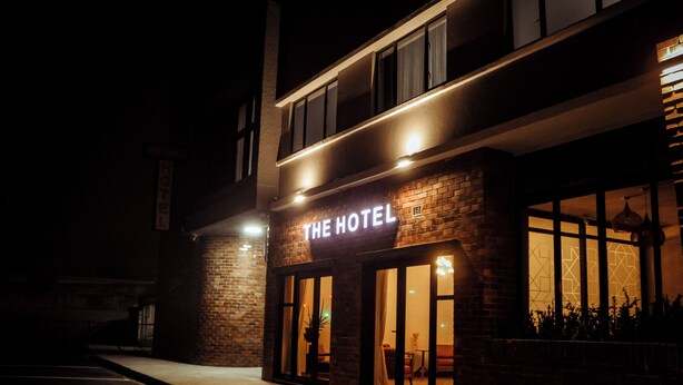 A hotel with a brick facade, large windows, and a sign that reads 'THE HOTEL'. - Railway Hotel (Wellington)