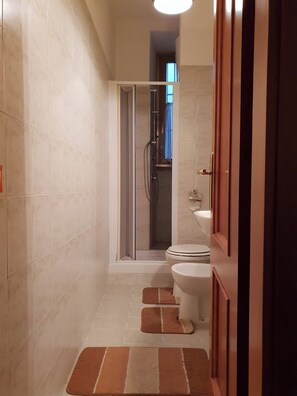 Ein modernes Badezimmer mit Glasdusche, Toilette und Waschbecken.