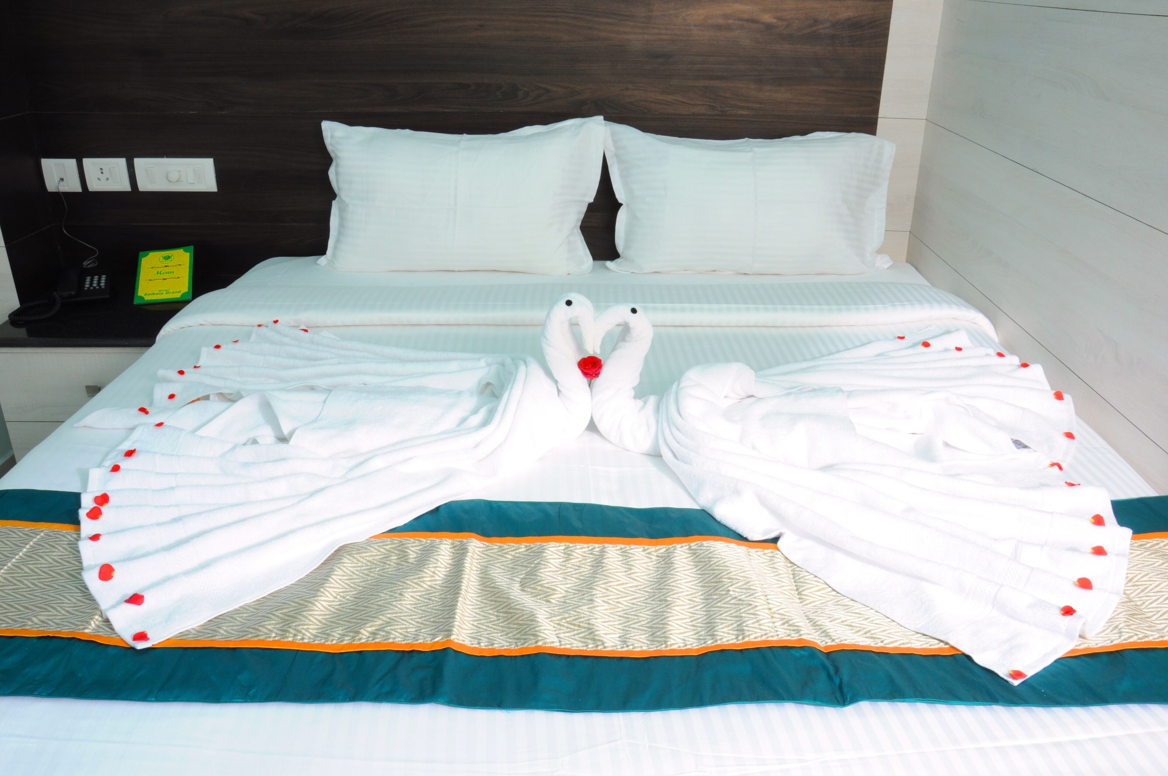Quarto de hotel com cama, almofadas, telefone e sinalização de cardápio.
