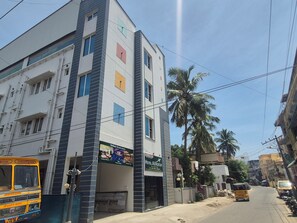 A multi-story building with a sign for 'Hotel Aerostay' and a bus parked in front.