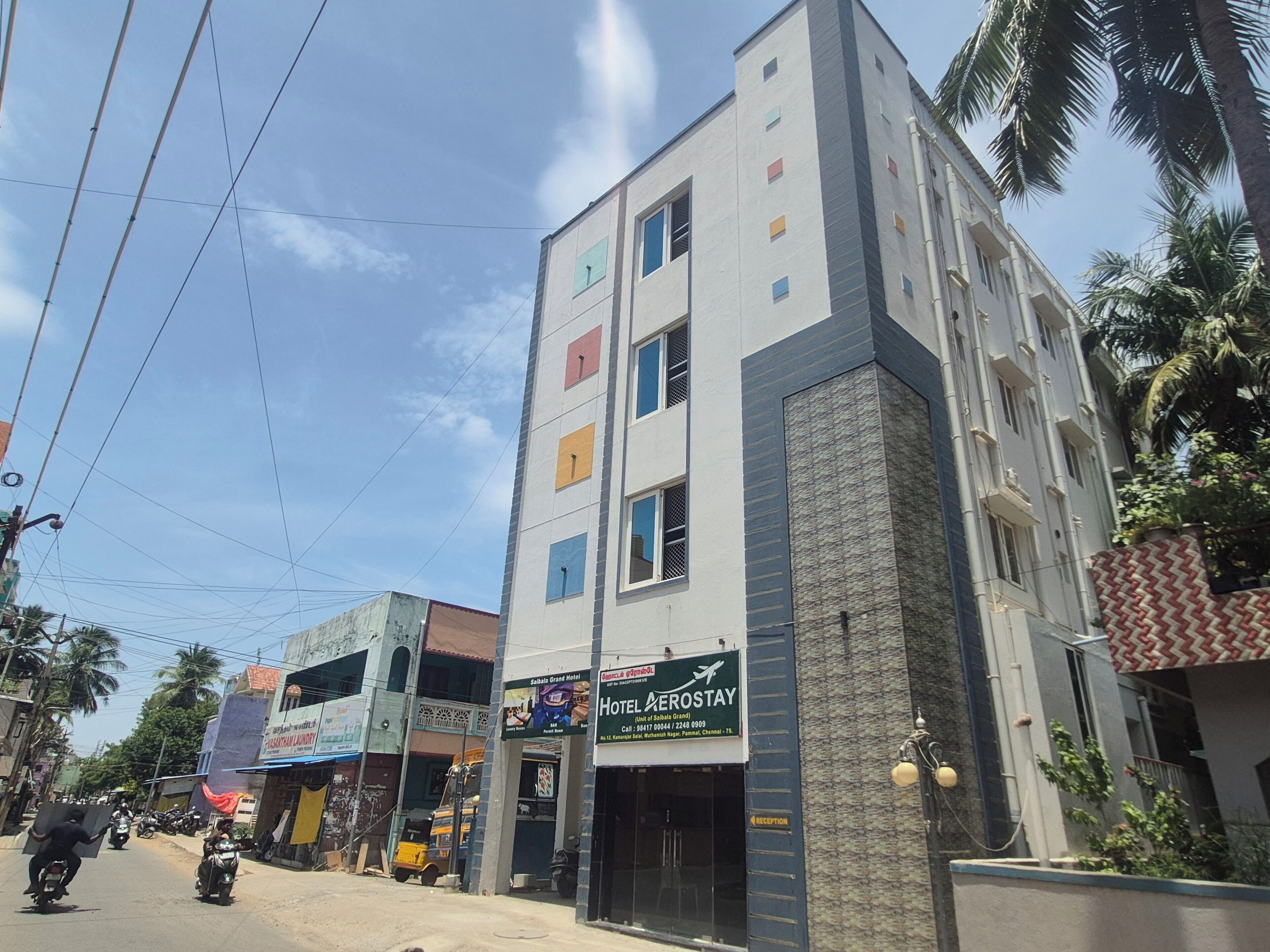 Un hôtel à plusieurs étages, avec une enseigne indiquant « Hôtel Aerostay » et un espace d’accueil.