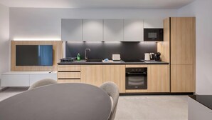 Cocina moderna con televisión de pantalla plana, microondas, lavabo y lavavajillas.