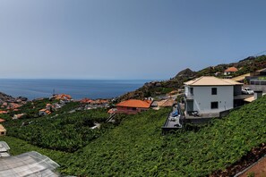 Un pueblo costero con casas escalonadas, una vista despejada del mar y un edificio blanco destacado con un balcón.