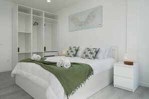 A bedroom with a bed, a nightstand, a wardrobe, and a wall-mounted artwork. - Exclusive Oceanview 2-bedroom Apartment|Sol & Mar (Câmara De Lobos)