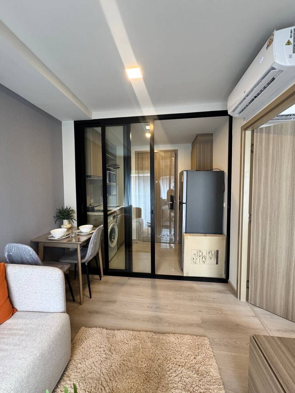 A compact living space with a kitchenette, a dining area, and a sofa.