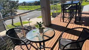 A balcony with a round glass table, two chairs, and a potted plant. - Pasadena Vista - Your Perfect Holiday Escape (Portarlington)
